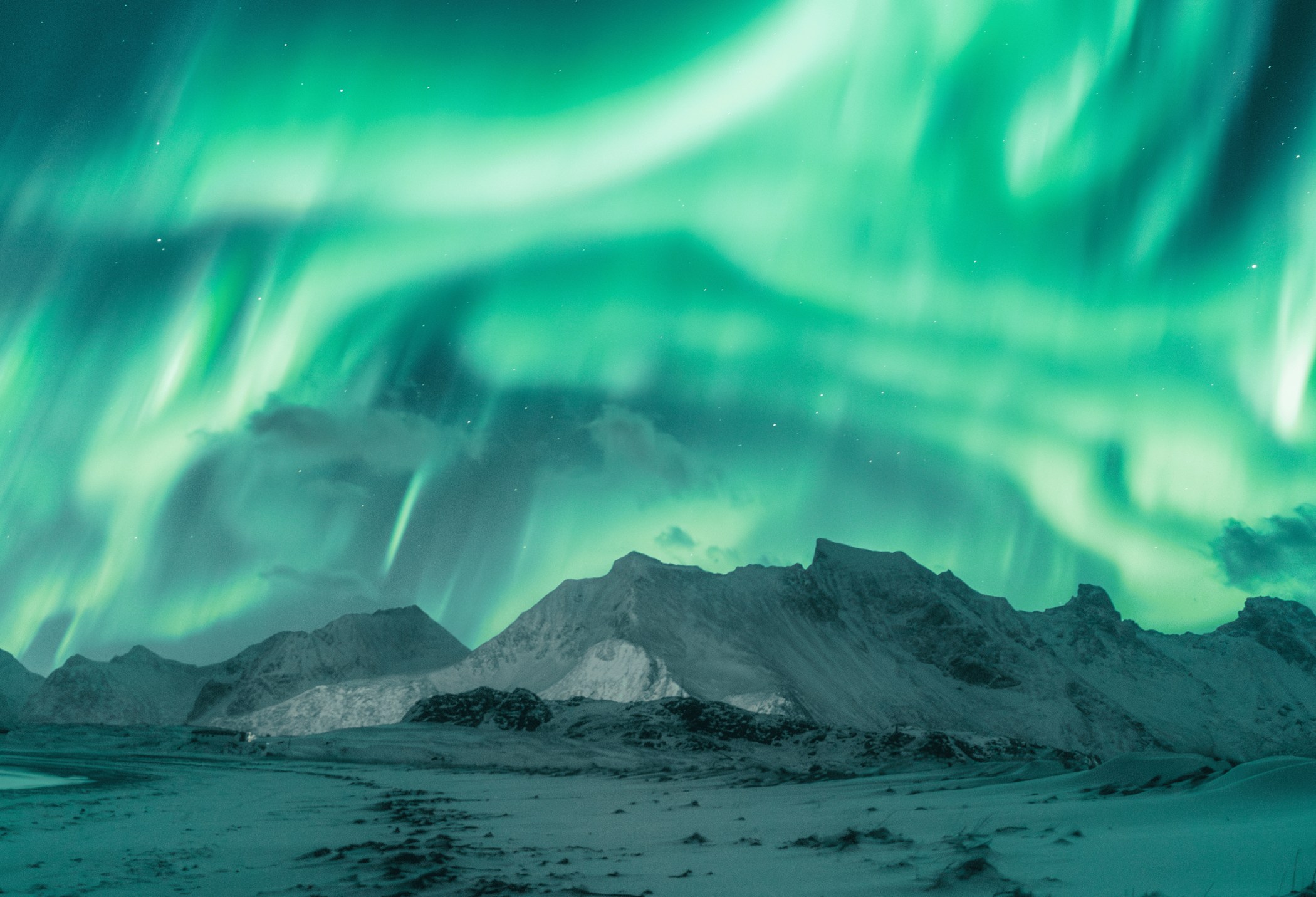 Northern lights above snow-covered mountains