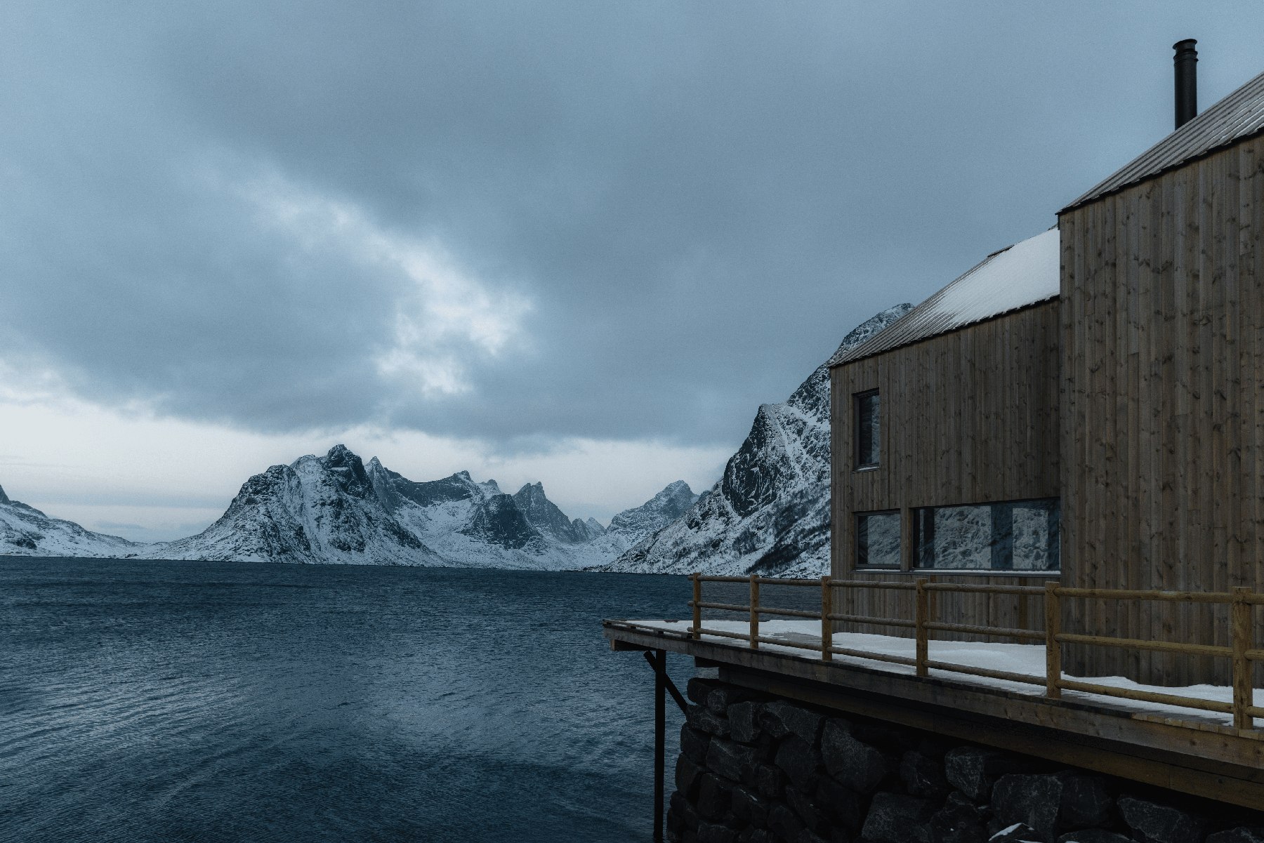 A home beside a winter fjord